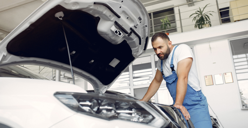 Un mecánico inspeccionando un motor en pleno trabajo en un taller.