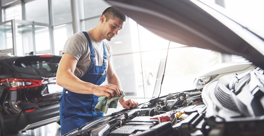 Un mecánico revisando el motor de un automóvil en un taller.